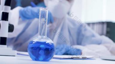 手持镜头科学家添加试剂蓝色的液体